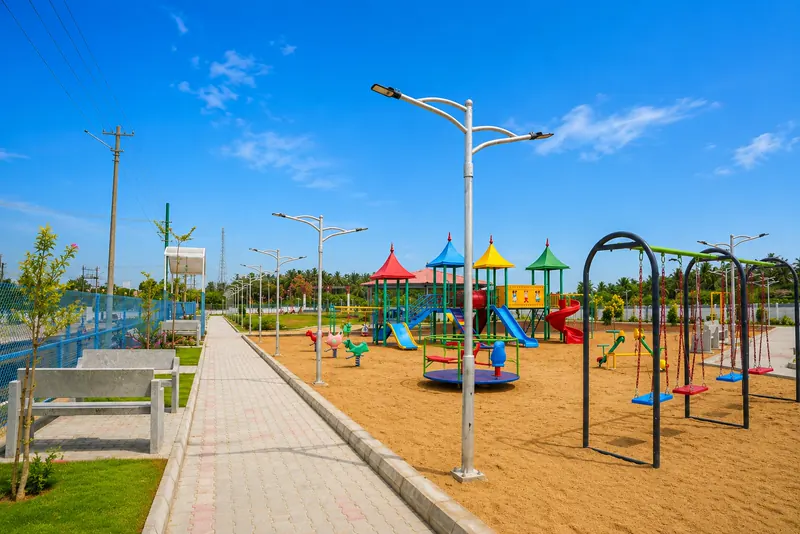 The kids' play area with slides, swings and a merry-go-round on sand